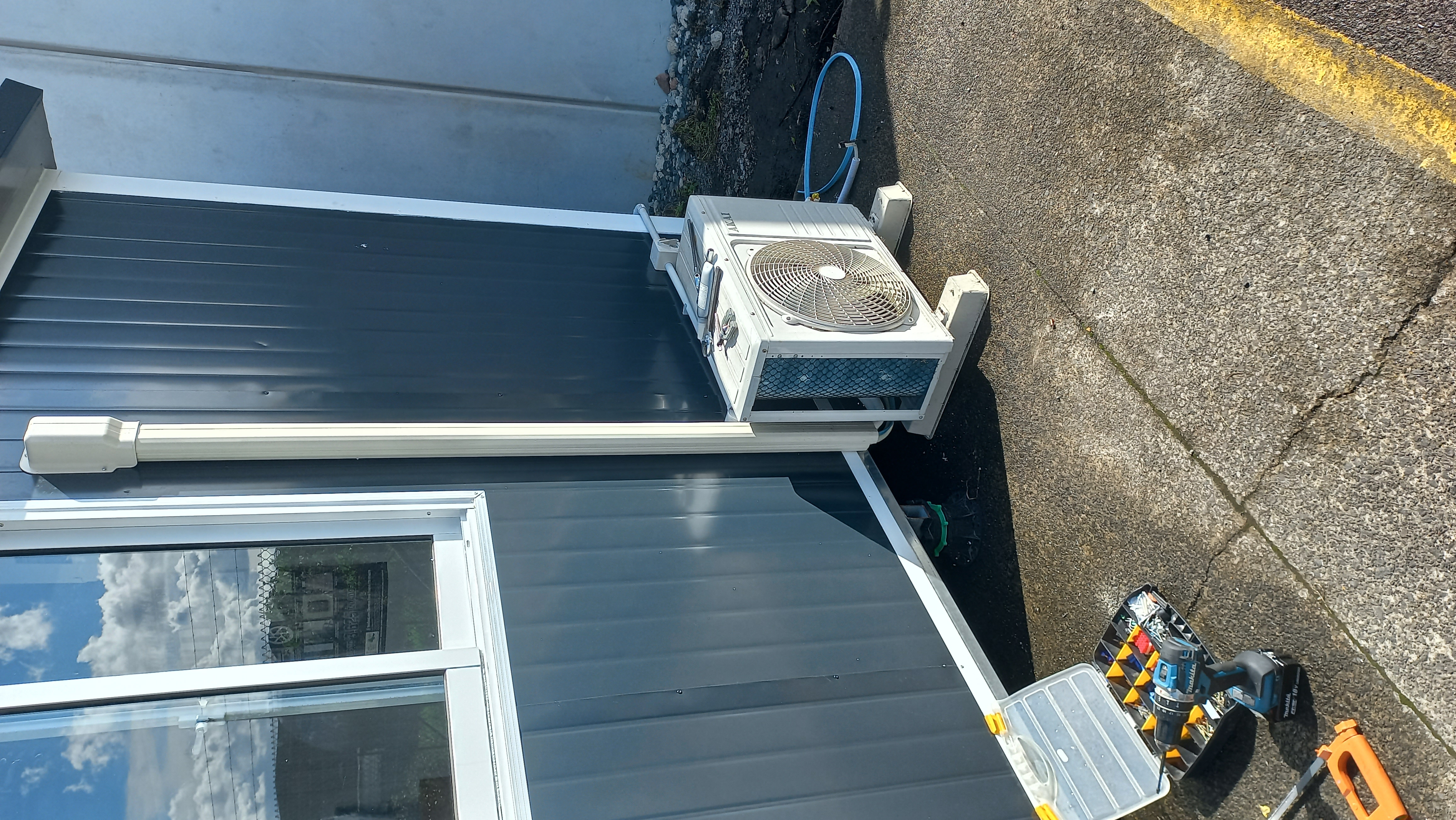 A modern heat pump unit installed on the exterior wall of a house
